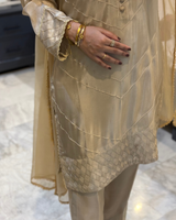 Beige traditional outfit with intricate patterns on a textured surface