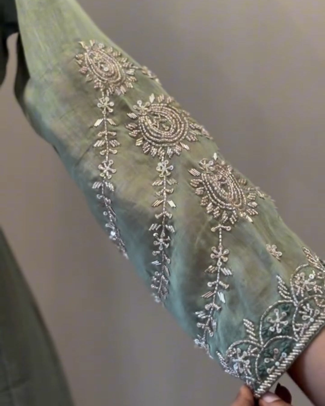 Decorative fabric with intricate silver embroidery on a plain background