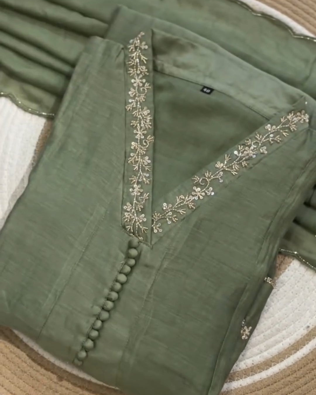 Green saree with intricate patterns on a textured surface