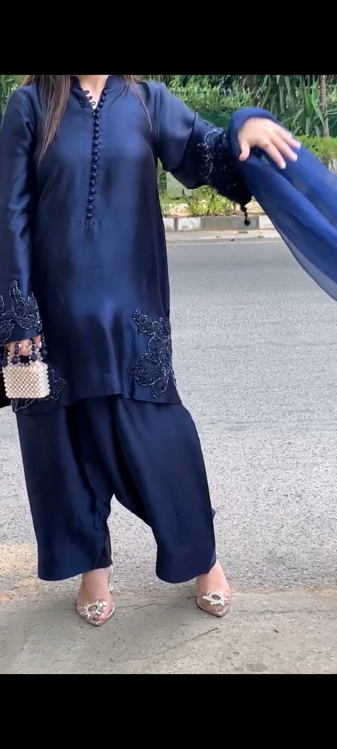 Person wearing a navy blue traditional outfit with a matching dupatta on a road background